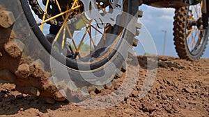 A cross-country sports motorcycle starts off on a dirt track and skids off into the distance.