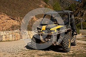 A cross-country vehicle (all-terrain vehicle) for off-road tourist trips on a road in the mountains. Close-up.