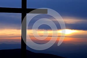 Cross at dawn in the mountains