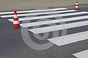 The cross-decorated pedestrian crossing with the still not dried out red. Restriction of traffic by road signs. Update road pedest