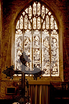 Cross In Front Of Blurred Stained Glass In Sepia Tone