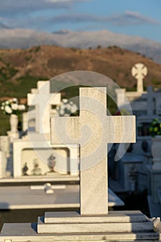 Cross on a grave in a Greek cemetery at dawn