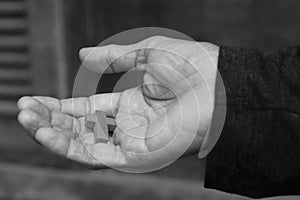 Cross in hand. Wooden small holy cross on a senior Christian man hand closeup in black and white. In deep feeling of love. photo