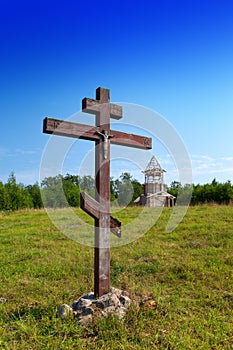 Cross in honor of the basis of church and under construction orthodox church on a hill