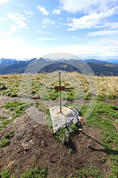 A cross with the inscript `Berg heil` stands directly aside the mountain trail above the Reiteralm photo