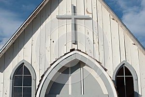 Cross on an old white clapboard church in rural America.