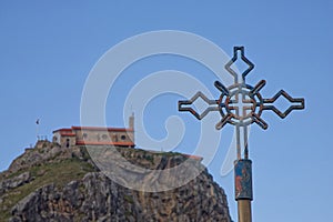 Cross of one of stations of the Cross with San Juan de Gaztelugatxe in background