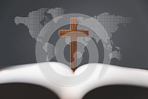 Cross with open Holy Bible on table with world map blur background. mission evangelism and gospel on world. Copy space for text, photo