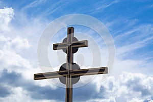 Cross religious Christian symbol against sky and white cloud