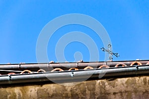 A cross on the roofs in the blue sky photo