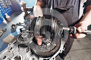 Cross-section of a car gearbox. mechanics work in the garage. hand mechanic in working clothes