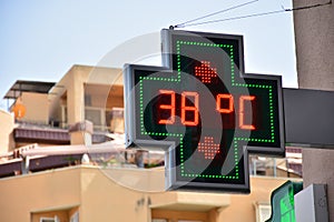 Street thermometer of a pharmacy at 38 degrees celsius photo