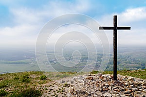 A cross on the site of a destroyed chapel. Top view of a rural landscape with a village