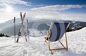 Cross ski and Empty sun-lounger at mountains in winter