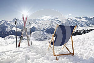 Cross ski and Empty sun-lounger at mountains in winter