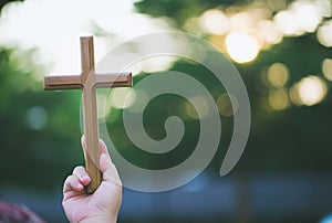 The cross standing on meadow sunset and bokeh background