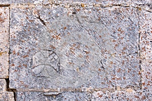 Cross. Stonemason mark in ashlar of the church of La Piedra, Burgos, Castilla y Leon, Spain photo