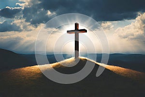 A cross on top of the hill backlit by soft light beams. Cross on top of mountain.