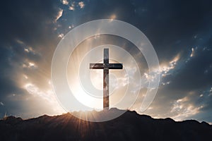 Cross on the top of a hill with dramatic sky and sun rays