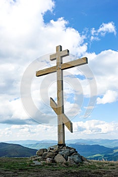 The cross on top of the mountain. Cross against the sky. Wooden cross on a hill. Christian cross.