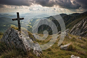 Cross on the top of the mountain with rays of light coming through the clouds