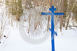 Cross on a tree in the winter forest