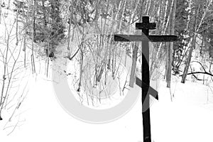 Cross on a tree in the winter forest