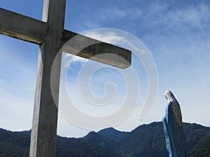 Cross and Virgin Mary in front of mountains