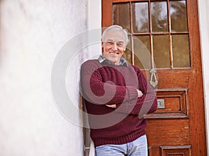Crossed arms, door and portrait of senior man at his home with positive, good and confident attitude. Happy, pride and
