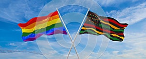 crossed flags of lgbt and Black history month USA and Canada flag waving in the wind at cloudy sky. Freedom and love concept.
