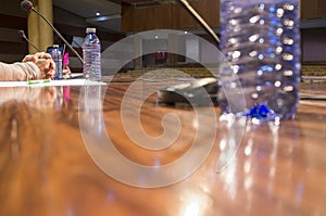 Crossed hand of speaker over table with no people at conference hall photo