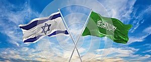 crossed national flags of Israel and Saudi Arabia flag waving in the wind at cloudy sky. Symbolizing relationship, dialog, photo