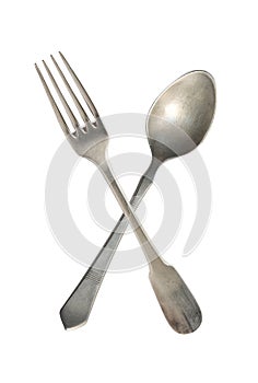 Crossed vintage spoon and fork isolated on bell background. Rustic style