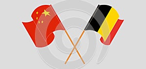 Crossed and waving flags of Belgium and China