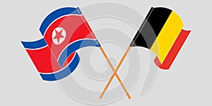 Crossed and waving flags of North Korea and Belgium
