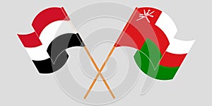 Crossed and waving flags of Oman and Yemen