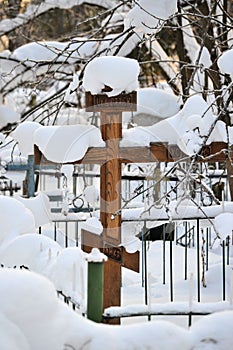 Crosses in a cemetery, monuments of the dead, a cemetery in winter, wreaths, artificial flowers. Russia