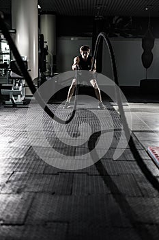 Crossfit battling ropes at gym workout exercise. Crossfit