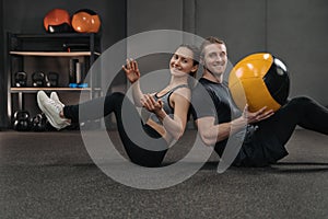 Crossfit couple exercising together with a ball