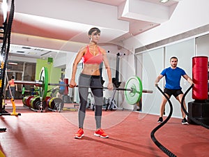 Crossfit gym weight lifting bar woman man battling ropes