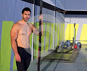 Crossfit man with climbing rope relaxed at gym