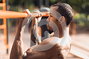 Crossfit man working out pull-ups on chin-up bar