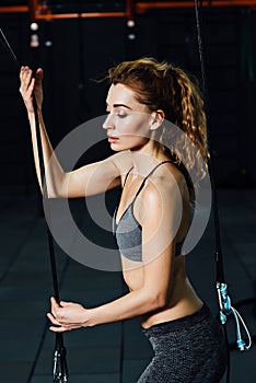 Crossfit woman standing with her front in the gym.