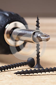 Crosshead screwdriver and screws lie on a sheet of fiberboard. Illustration on the topic of construction or repair of a house