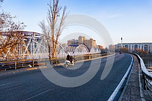 Crossing the Blue Iron Bridge in Zaragoza by motorcycle at sunrise. .Cruzando el Puente de Hierro azul en Zaragoza en moto al photo