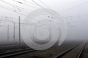 Crossing railways disappearing in the mist in autumn morning