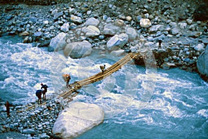 Crossing a suspension bridge over the Kali Gandaki photo