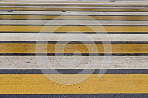 Crosswalk on the street with white and yellow stripes