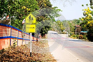 Crosswalk warning sign at school area.