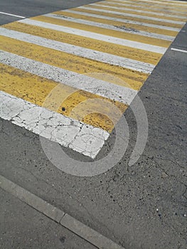 Crosswalk. yellow and white stripes on the asphalt